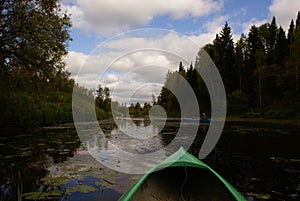 View of the river in the taiga from a green kayak