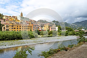 View from a riverbank across the river Roya of the village of Ventimiglia Italy, and inland to the mountains of the Imperia region
