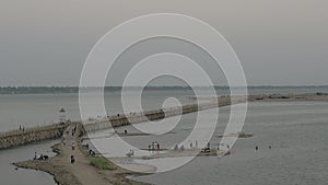 View riverside of people and vehicles crossing a bamboo bridge at night