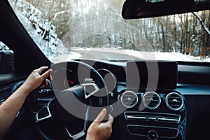 View of the road, drivers view. Man driving on a snowy mountain road