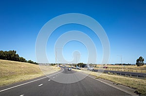 View of a road merging to the highway at the outskirt of Melbourne`s urban area. Background texture of the Australian motorway