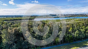 View of a road next to seashore near Settlement Point surrounded by green trees Port Macquarie, NSW