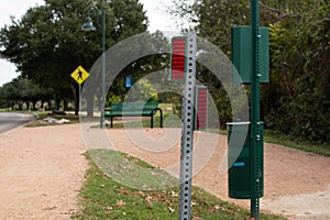 View of a road by the park with roadsigns and a bench