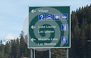 View of road sign with directional arrows point to `Lake Louise` and `Moraine Lake`