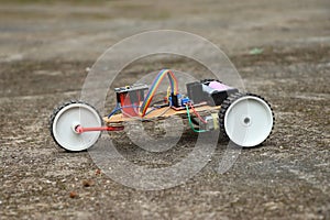 View of a robotic car having 3 wheels. Robot car that is controlled using a programmable micro controller board working prototype