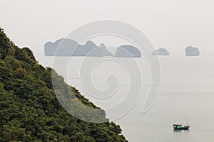 View on rock islands with fishing boat in Ha Long Bay near to Cat Ba, Vietnam