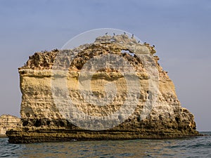 View of a rock islet on Marinha beach from a boat Algarve, Portugal