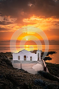 view from a rock on the typical greek church Chapel of Agios Nikolaos on zakyntos, sunrise at the sea