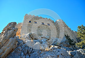 View of a rock wall with walls and a medieval castle