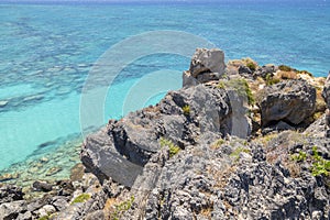 View of the rocks and crystal clear water of The Mediterranean Sea on the background