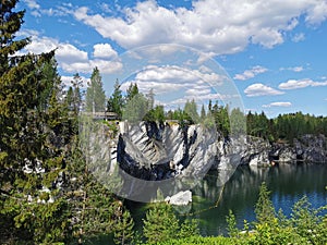 View of the rocks and the emerald water of the Marble Canyon in the Ruskeala Mountain Park, which reflects the sky and rocks on a