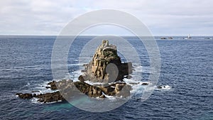View of rocks from Lands End Cornwall England with Longships lighthouse