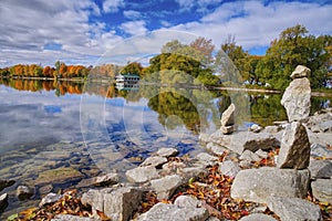 View of the rocky coast shore with the reflection of fall color in the lake