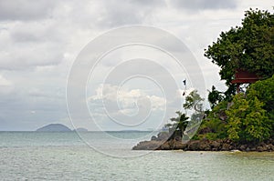 View of rocky coastline and tropical sea with small islands on horizon on the tropical Koh Chang island in Thailand