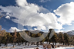 View of the Rocky Mountains at Pikes Peak, snow covered winter landscape under a blue sky with bright white clouds