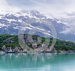A view of the rocky, verdant shoreline close to the Margerie Glacier in Glacier Bay, Alaska