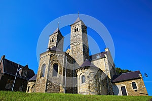 View on roman basilica and monastery from 11th century with two towers on green hill against blue summer sky - Sint Odilienberg,