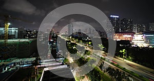 View from the roof to the busy highway, shopping center and high-rise buildings, clouds and lightning on the horizon. Timelapse of