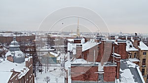 View of the roofs of the winter city. Houses with chimneys in the snow
