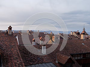 View of rooftops with beautiful roof tiles in the old medieval city of Murten in Switzerland at dusk.