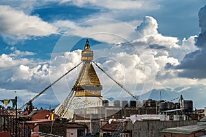 View from rooftops on Boudha stupa against the backdrop of a dramatic clouds over the mountains