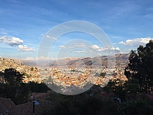 View of the rooftops of Cusco, Peru with the Andes mountains in the background