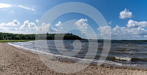 View of the Roskilde Fjord with a sandy beach and forest on the shoreline