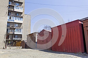 View on row of garages near by cheap residential building. Garages are widely used to keep cars and stuff in Russia and post-