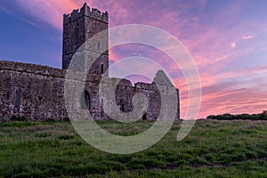 A view of the ruins of Clare Abbey a Augustinian monastery just outside Ennis, County Clare, Ireland with a beautiful sunset in