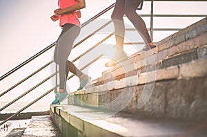 View of runners legs having a workout session on city stairs outdoor - Close up of people running at sunset