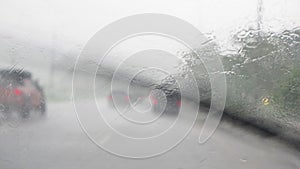 View through running car windshield during heavy rain.