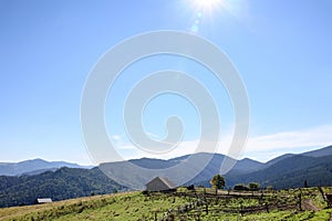 View of rural house in mountains on sunny morning. Space for text