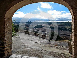 View of a rural landscape through the arched passage of Montfalco Murallat  fortified village in Catalonia Lleida, Spain. photo