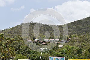 View of rural landscape featuring picturesque mountain range and quaint village in the foreground