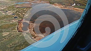 View of Russian tundra its rivers lakes ground from helicopter widow.