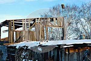 View of rustic wooden hayloft with birdhouse in winter. Abandoned village building.