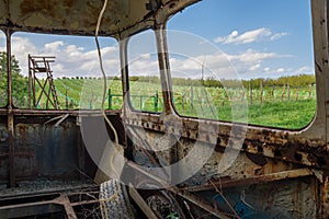 View of a rusty old bus on a spring landscape with lookout tower