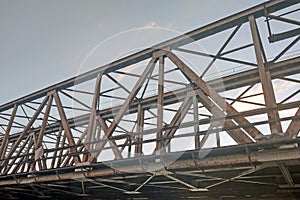Pohled na starý rezavý železniční most přes řeku.