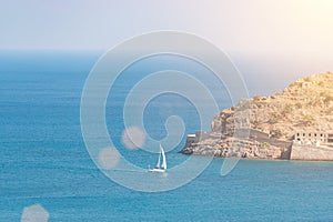 View of sailing boat and Spinalonga Island on Crete, Greece