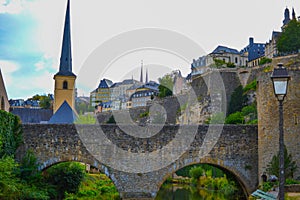 View of Saint Michael`s Church Eglise Saint-Michel in old town of Luxembourg City, Luxembourg, with an old stoned bridge and th