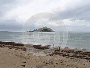 View of Saint Michael\'s Mount in Cornwall England from beach with sea weeds photo