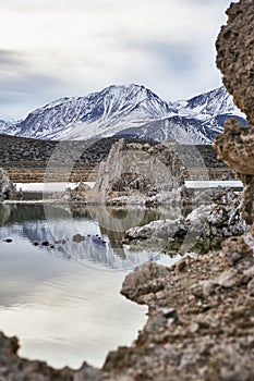 View of a Saline Soda Lake with Snow Capped Eastern Sierra Navada Mountains on a Cloudy Day in the Afternoon with Sunlight Shinnin photo