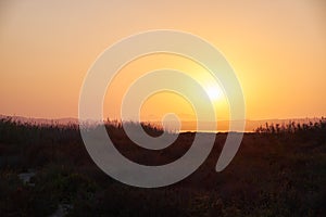 View of the salt lake with a beautiful pink water. Sunset orange sun, the neighborhood.Las salinas, Torrevieja, Spain