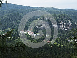 View from sandstone rock viewpoint Monchskanzeland on spruce tree forest, village Oybin and Zittauer Gebirge mountains