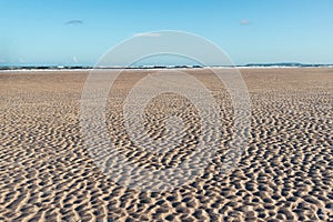 View of sandy beach against blue sky. Late afternoon photo