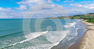 View of the sandy beach and the incoming blue waves. Shevelev.