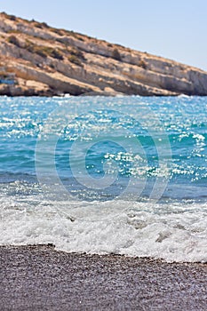 View of sandy beach, sealine, waves, cliff and blue sky in the summer sunny day