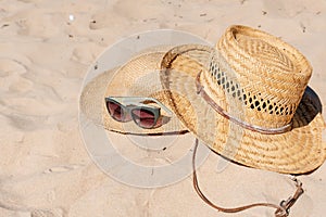 View of sandy beach with summer hats and sunglasses. Blank advertisement or packaging layout