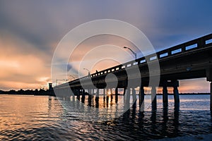 View of Sarasota Bay, Florida near Siesta Key Beach at sunset with view of road bridge disappearing into the distance. Colorful sk