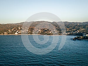 View of Sayulita Mexico beach looking east. Aerial view at sunset with waves crashing at point